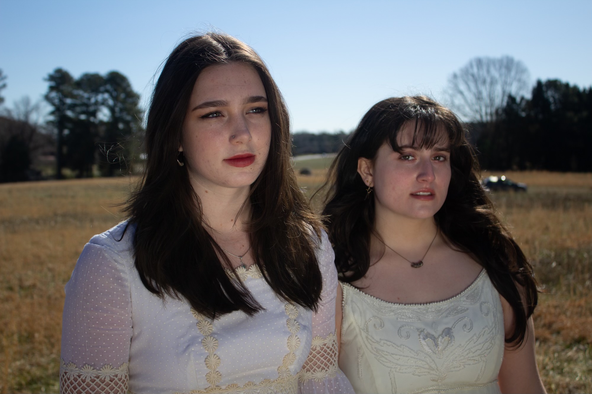portrait of 2 girls in white dresses looking at the camera